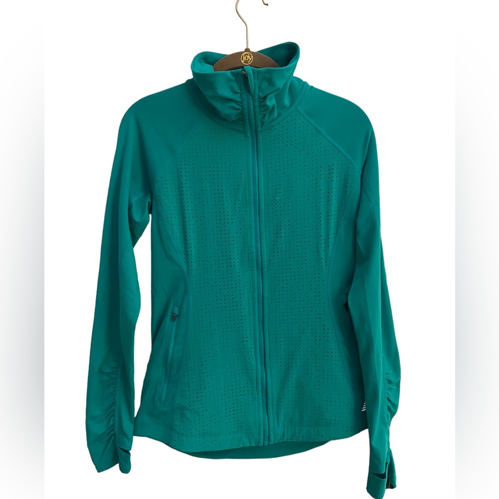 New Balance long sleeve zip up jacket with overlap thumb hole details.